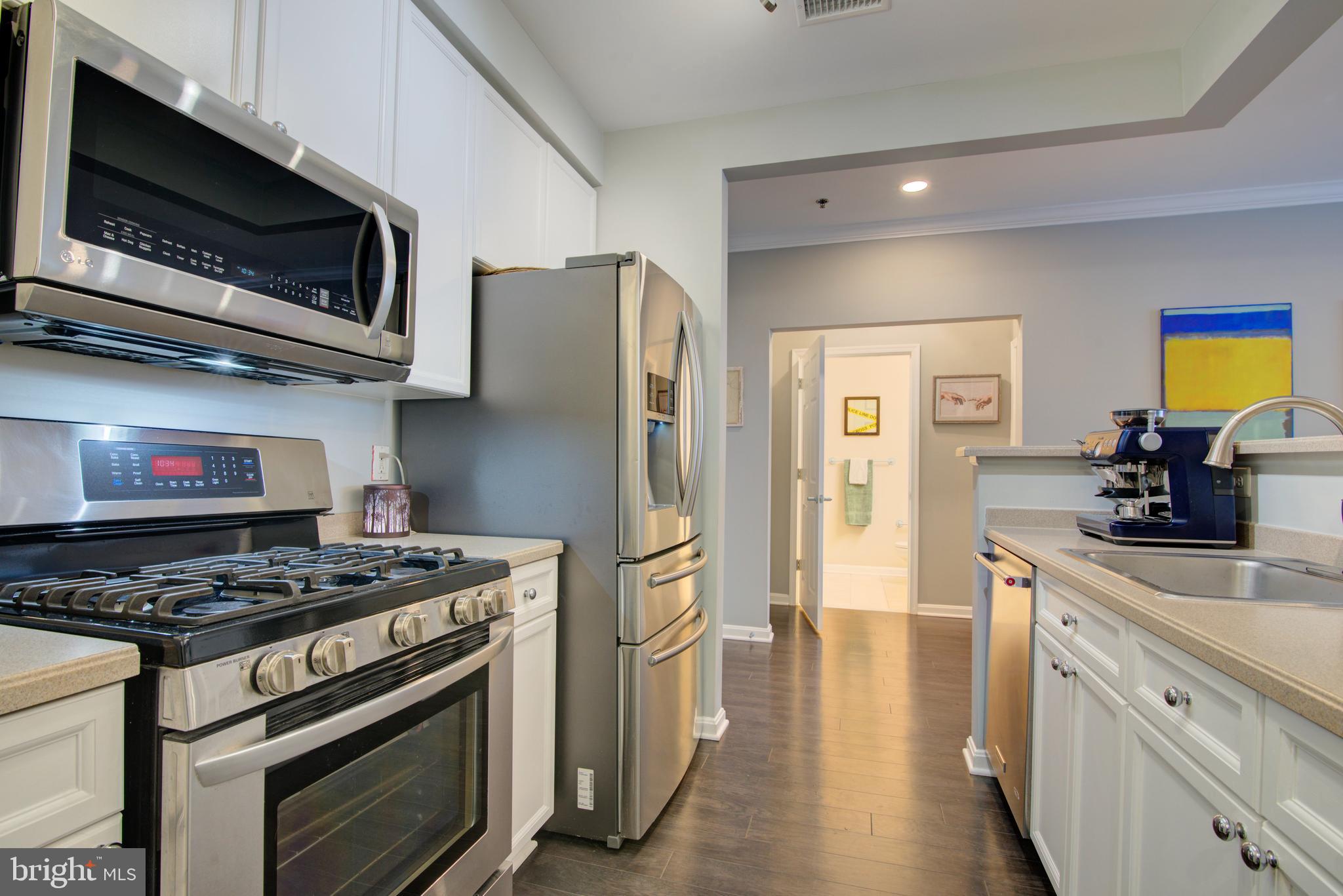 1855 Stratford Park Place, Unit 310 Reston, VA 20190 - Photo 11 of 62 a kitchen with stainless steel appliances a stove a microwave and a refrigerator