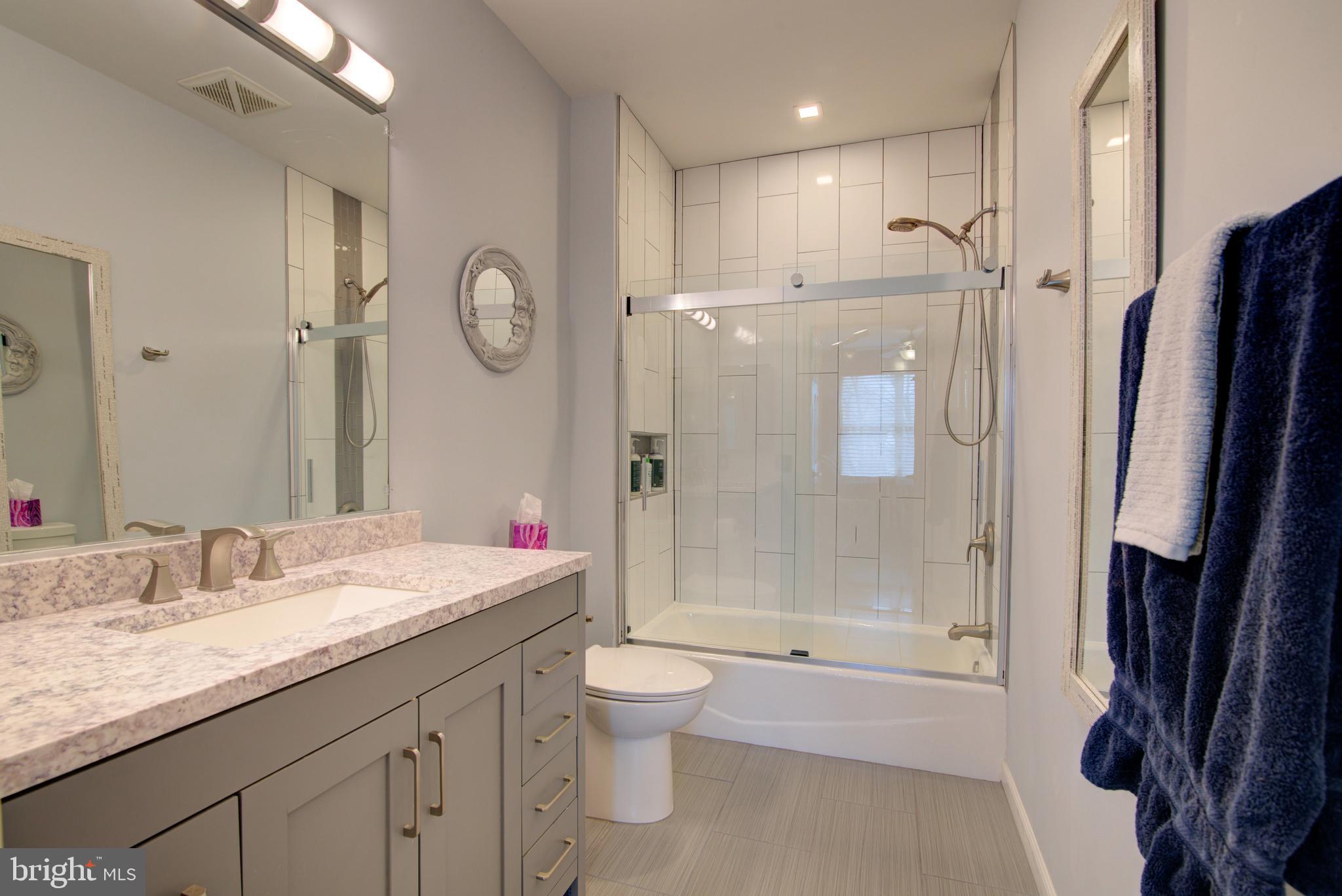 1855 Stratford Park Place, Unit 310 Reston, VA 20190 - Photo 16 of 62 a bathroom with a granite countertop sink toilet a mirror and shower