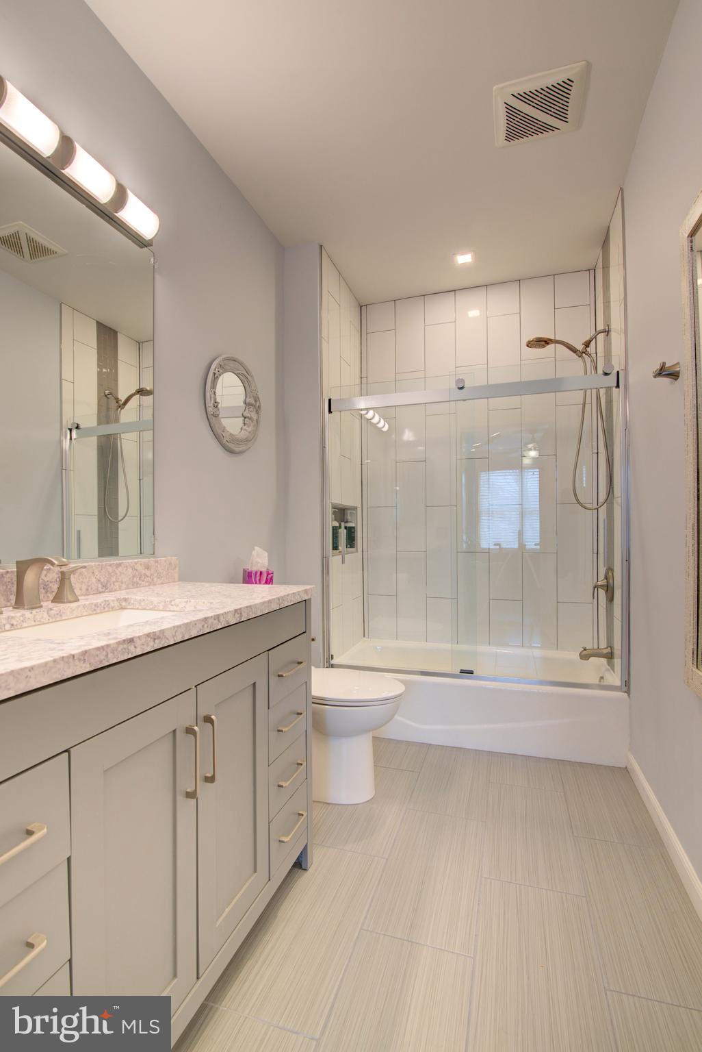1855 Stratford Park Place, Unit 310 Reston, VA 20190 - Photo 17 of 62 a bathroom with a granite countertop sink a toilet a mirror and shower