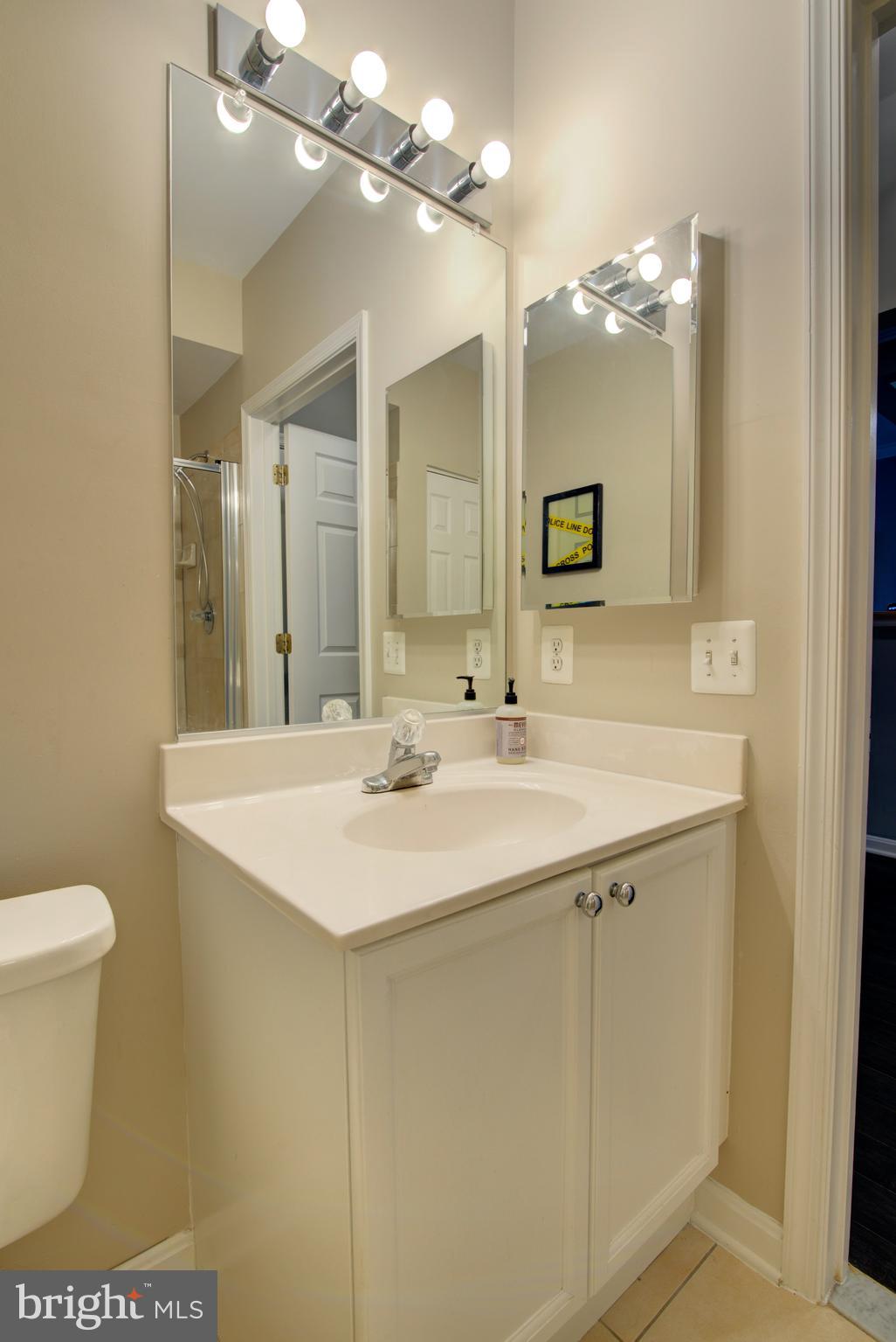 1855 Stratford Park Place, Unit 310 Reston, VA 20190 - Photo 21 of 62 a bathroom with a sink a toilet a mirror and shower