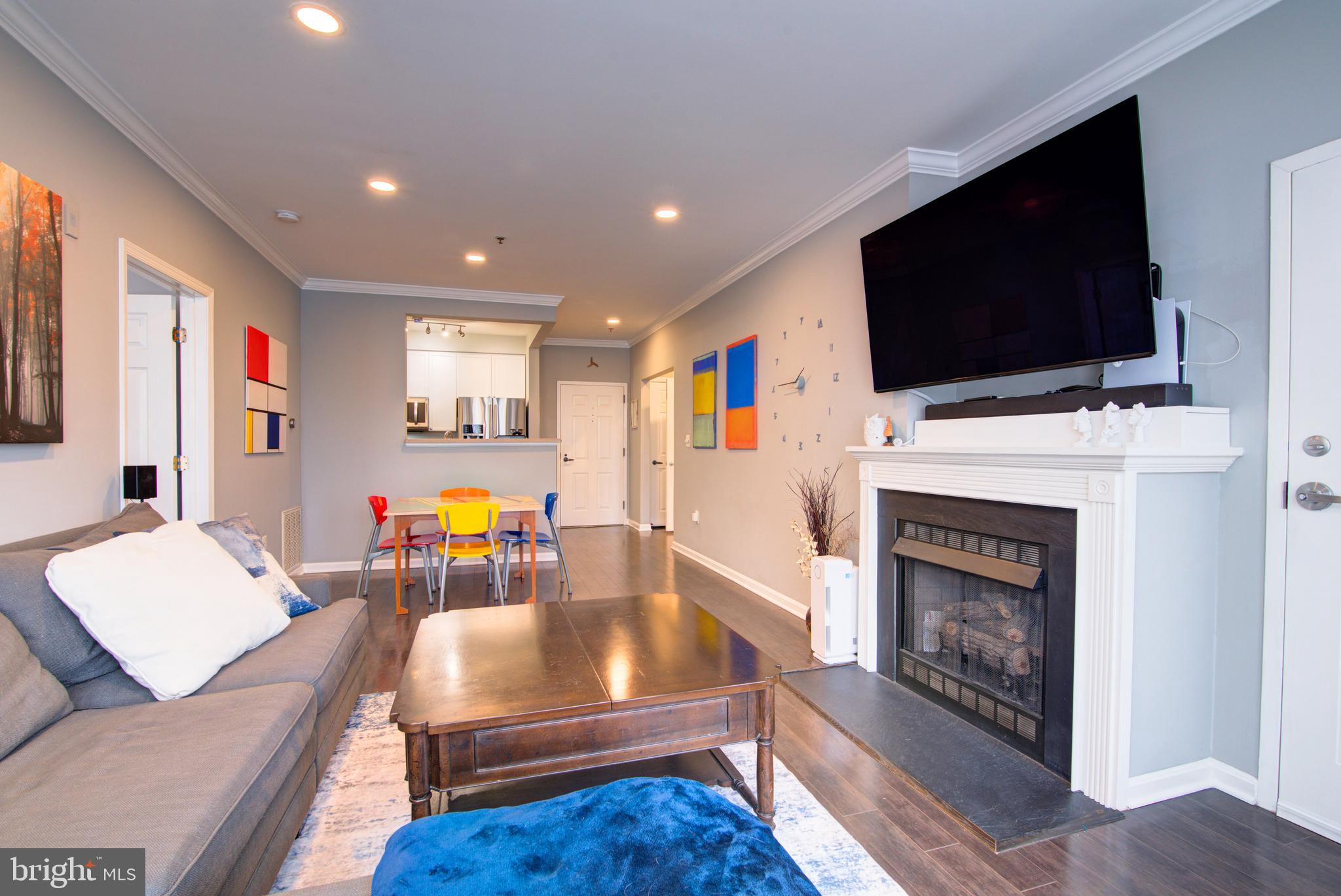 1855 Stratford Park Place, Unit 310 Reston, VA 20190 - Photo 2 of 62 a living room with furniture a flat screen tv and a fireplace