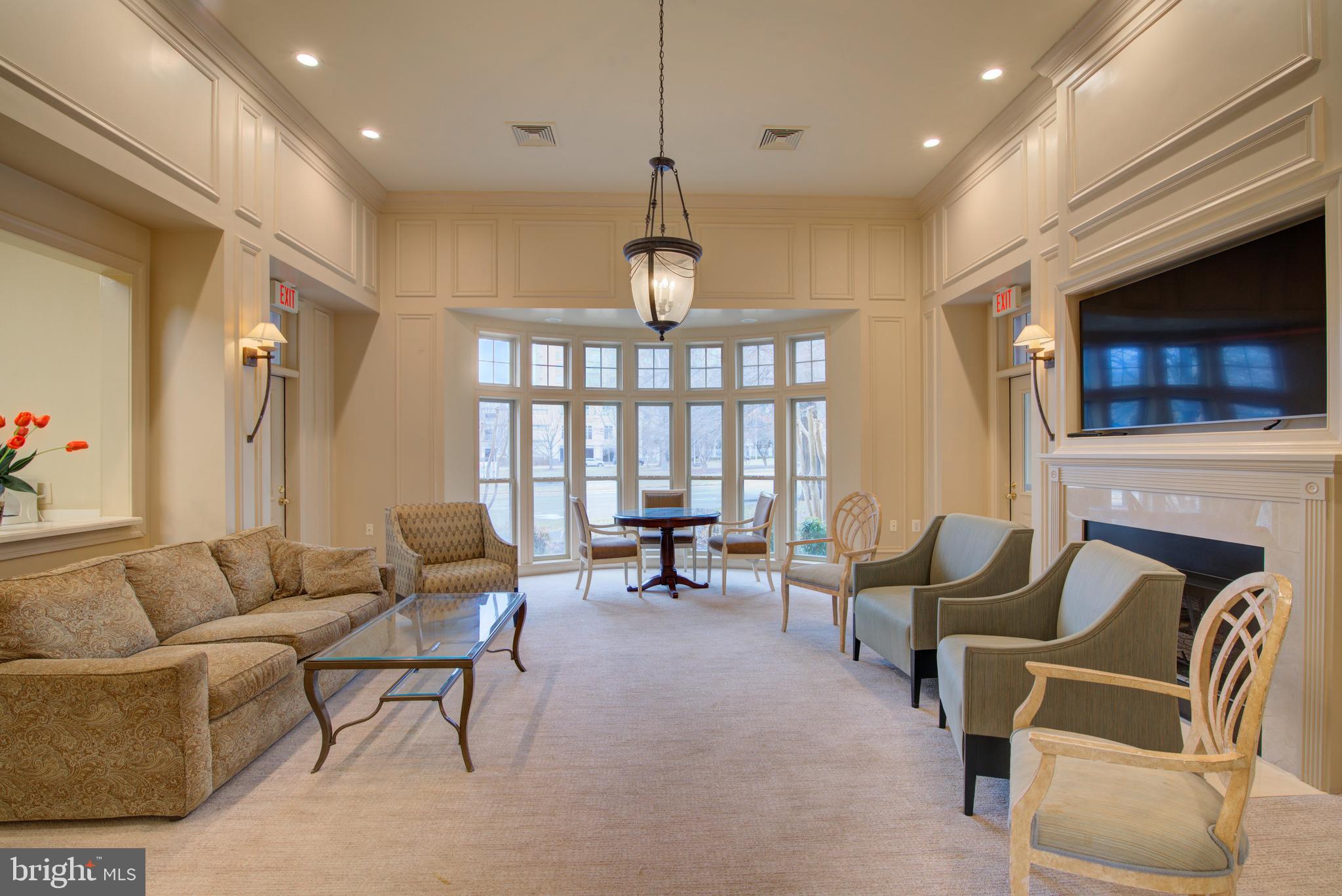 1855 Stratford Park Place, Unit 310 Reston, VA 20190 - Photo 40 of 62 a living room with furniture a fireplace and a chandelier