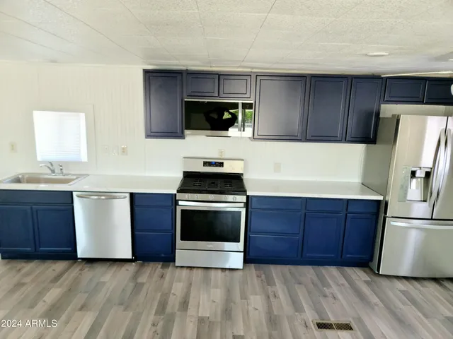 a kitchen with stainless steel appliances a stove a sink and a refrigerator
