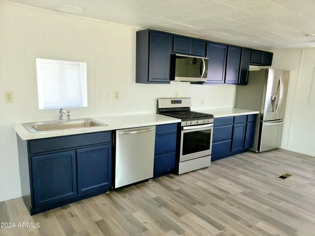 a kitchen with stainless steel appliances kitchen island granite countertop wooden cabinets a stove top oven a sink and dishwasher