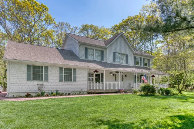 a front view of a house with a garden and yard