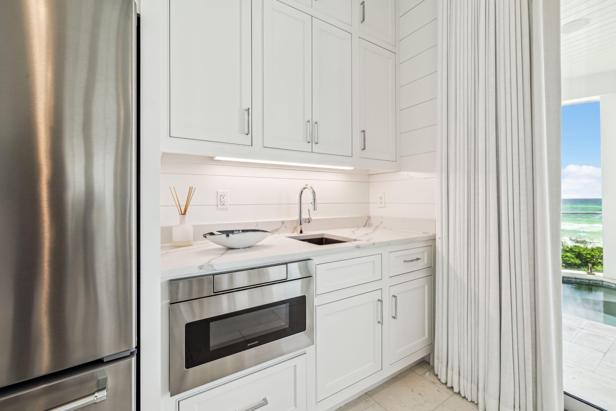 323 Pompano St Inlet Beach Inlet Beach, FL 32461 - Photo 9 of 79 a kitchen with white cabinets and white appliances