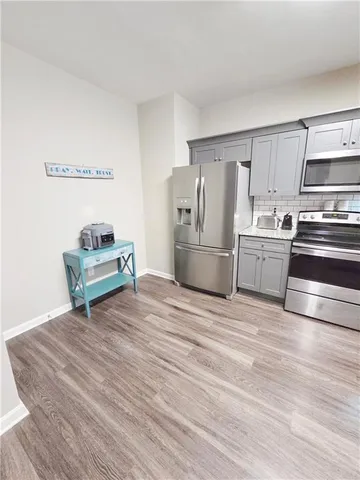 a kitchen with stainless steel appliances a stove refrigerator and microwave