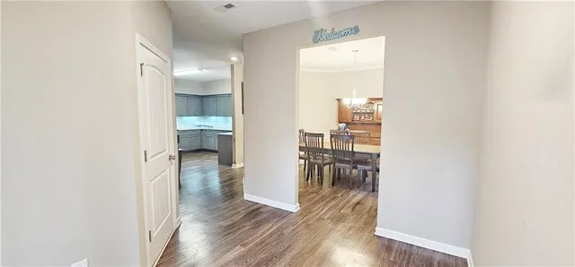 a view of a hallway with wooden floor windows and a kitchen