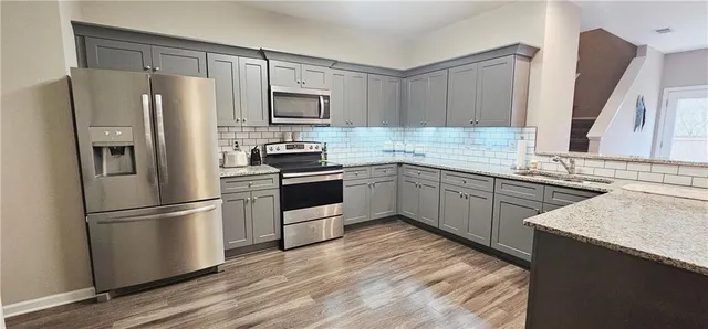 a kitchen with a refrigerator sink and wooden floor