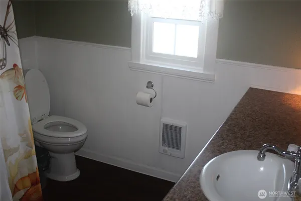 a bathroom with a sink a toilet and a mirror