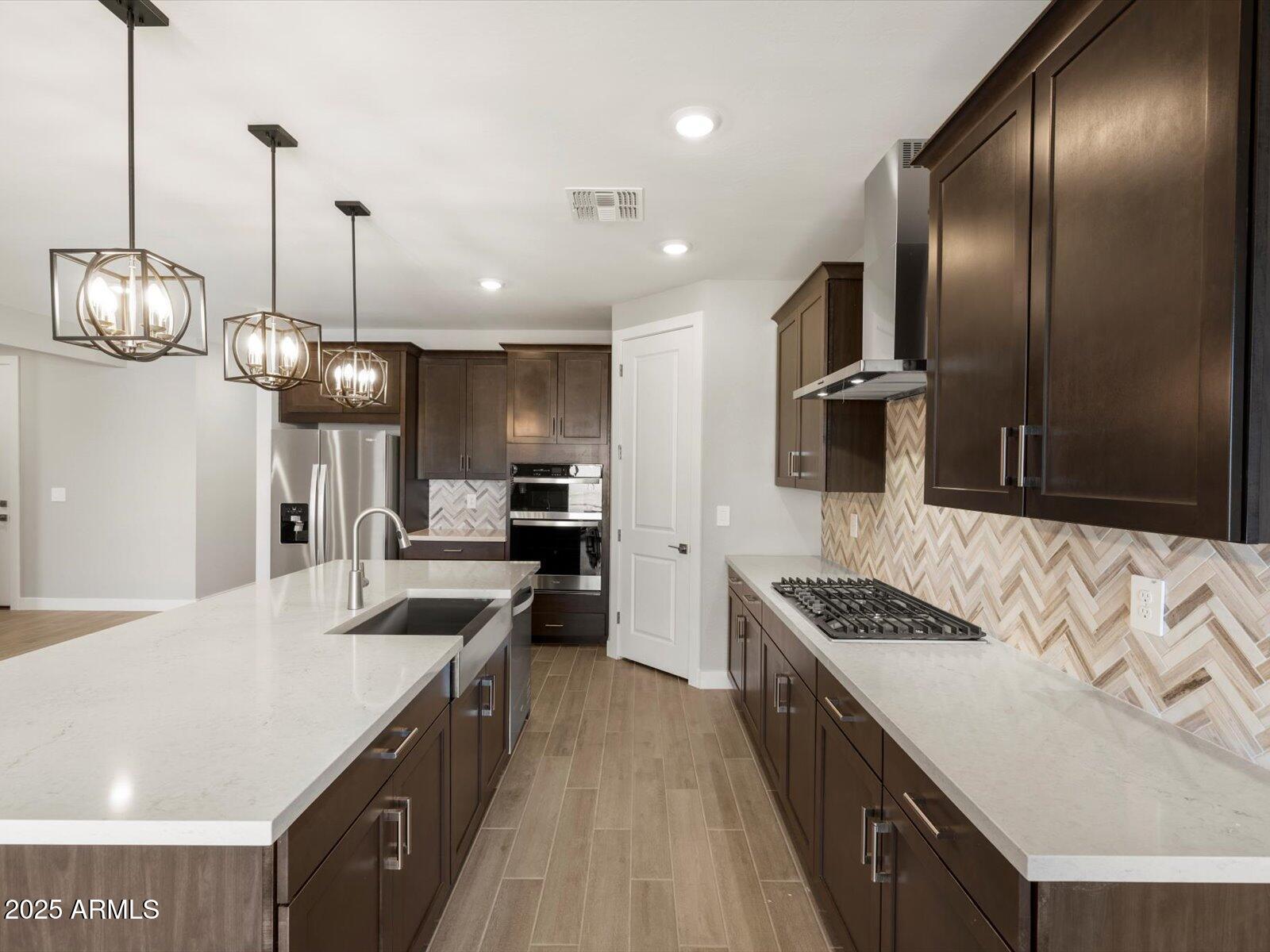 4818 North 178th Lane Goodyear, AZ 85395 - Photo 5 of 38 a kitchen with stainless steel appliances a sink stove and refrigerator
