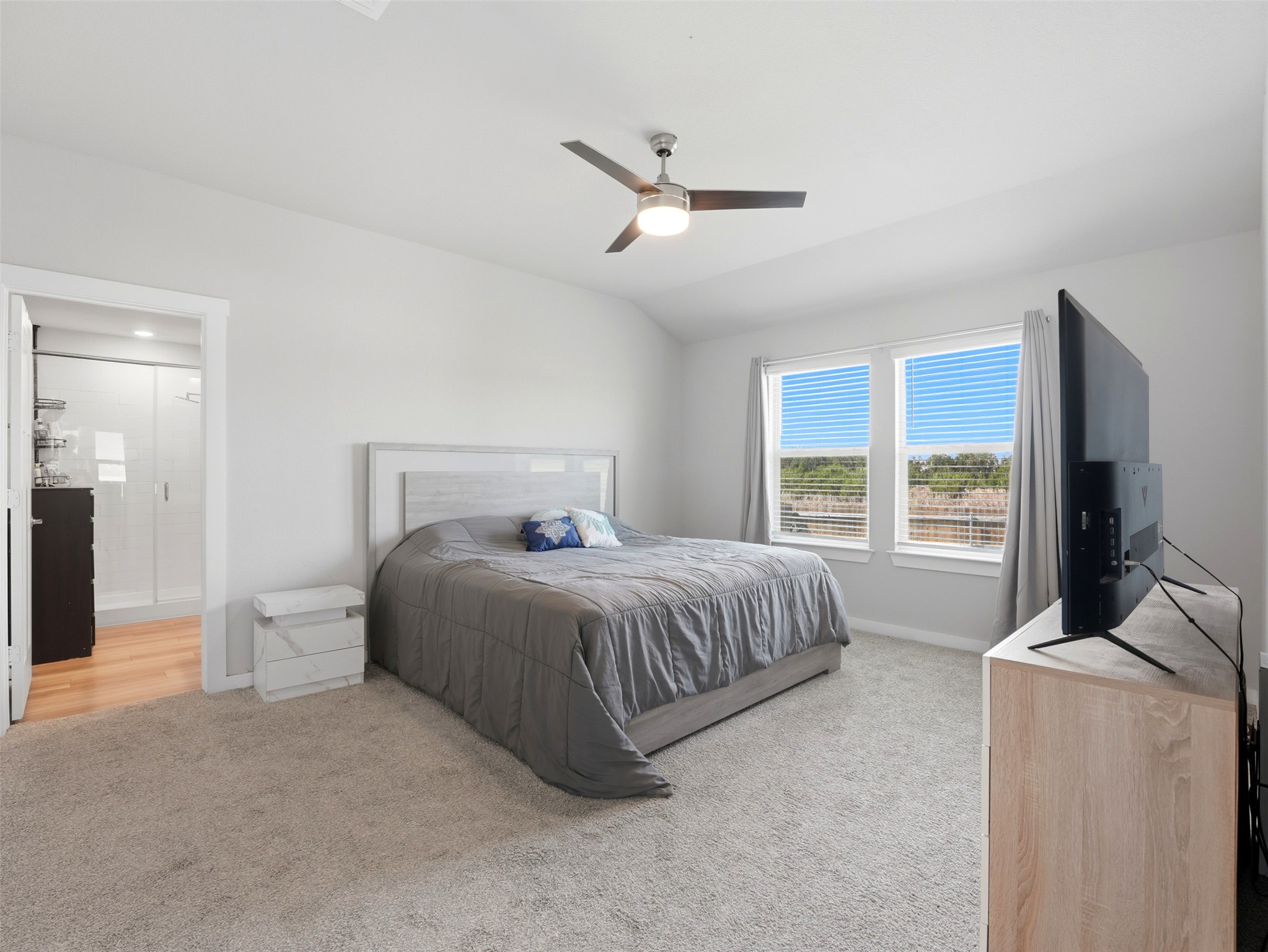 1024 Tipton Street Georgetown, TX 78633 - Photo 14 of 32 A well-lit primary bedroom features soft carpeting and an attached private bathroom with a walk-in shower.