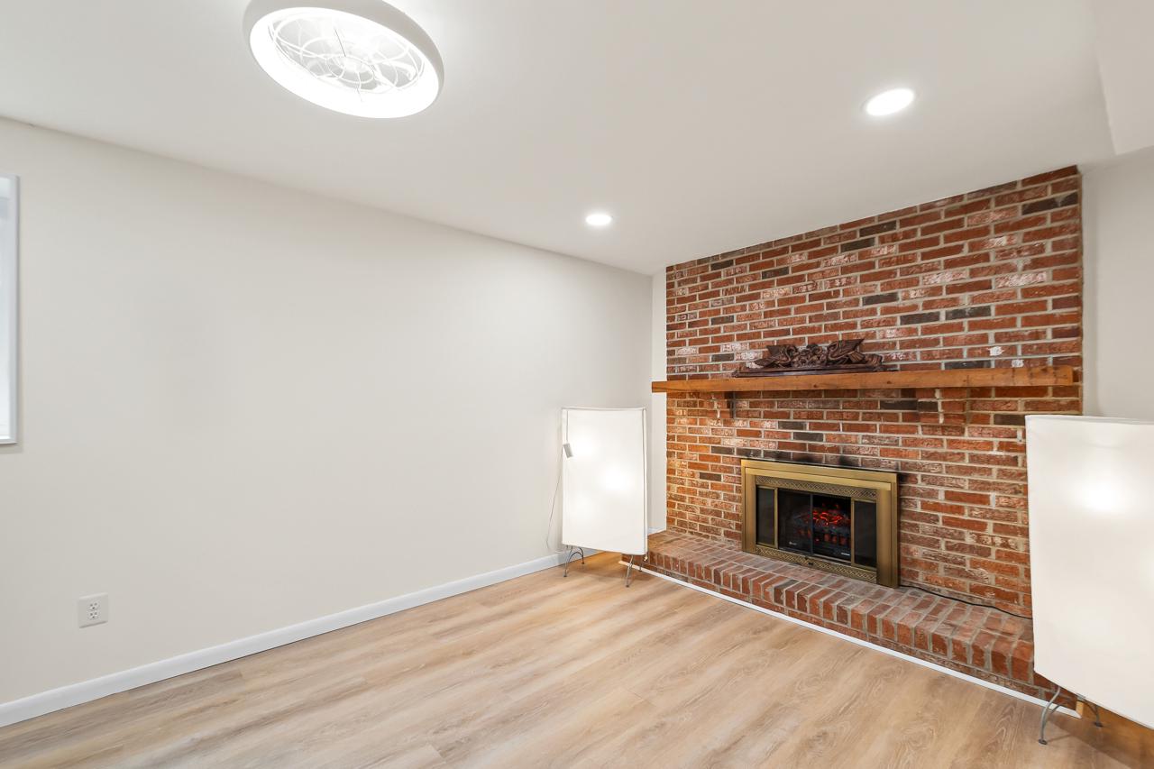 8450 Stonewall Road Manassas, VA 20110 - Photo 28 of 48 an empty room with wooden floor and fireplace