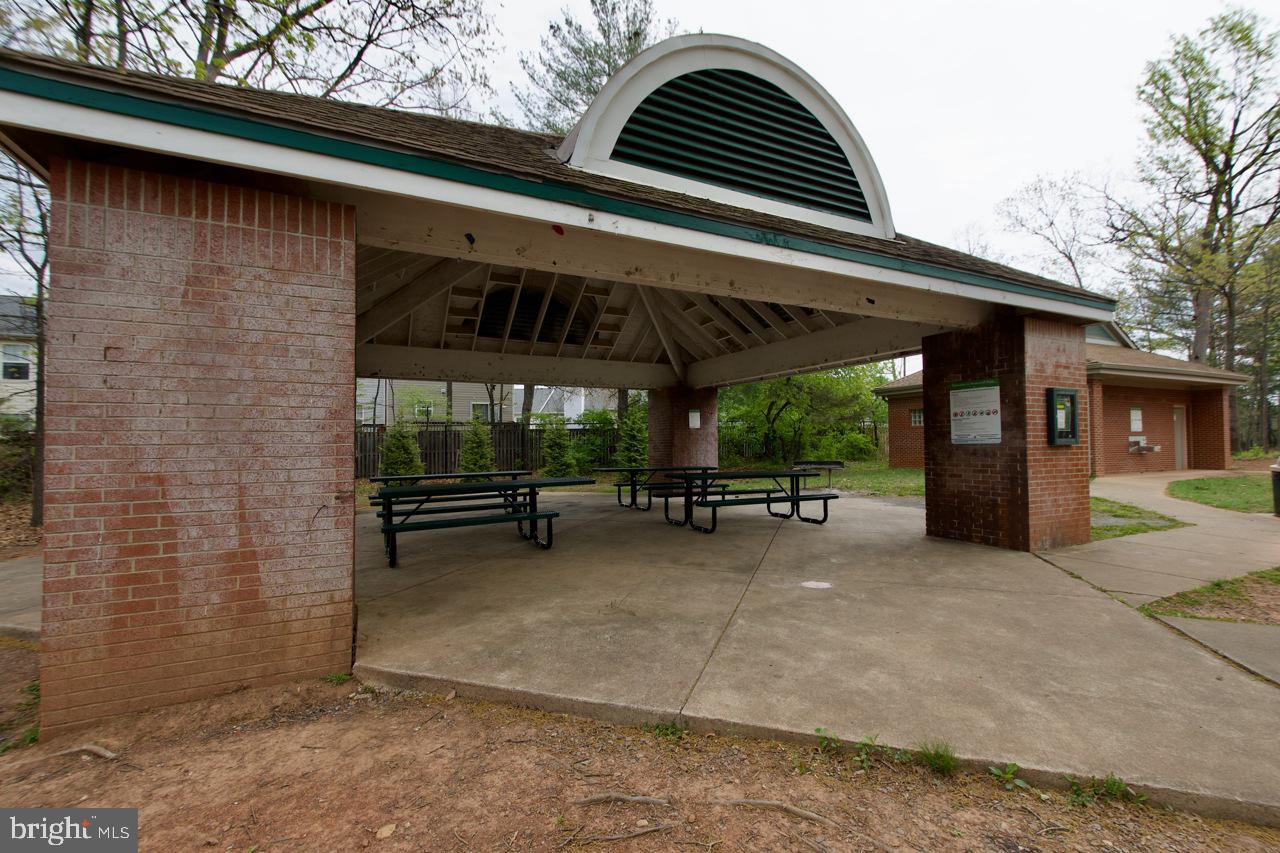 8450 Stonewall Road Manassas, VA 20110 - Photo 40 of 48 a view of a patio with table and chairs under an umbrella with a roof