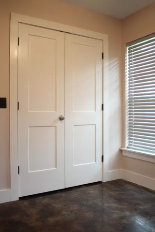 a view of a small space with wooden floor and fan