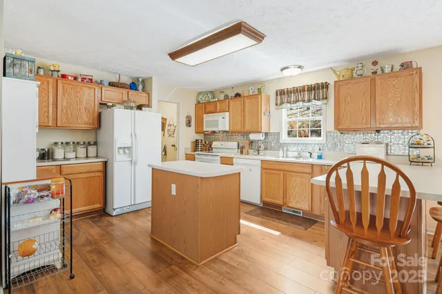 a kitchen with refrigerator cabinets and wooden floor