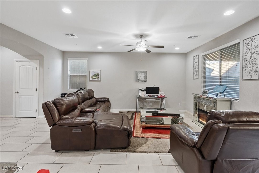 936 Keesey Way Henderson, NV 89052 - Photo 10 of 30 Living area featuring a glass covered fireplace, recessed lighting, light tile patterned flooring, ceiling fan, and arched walkways