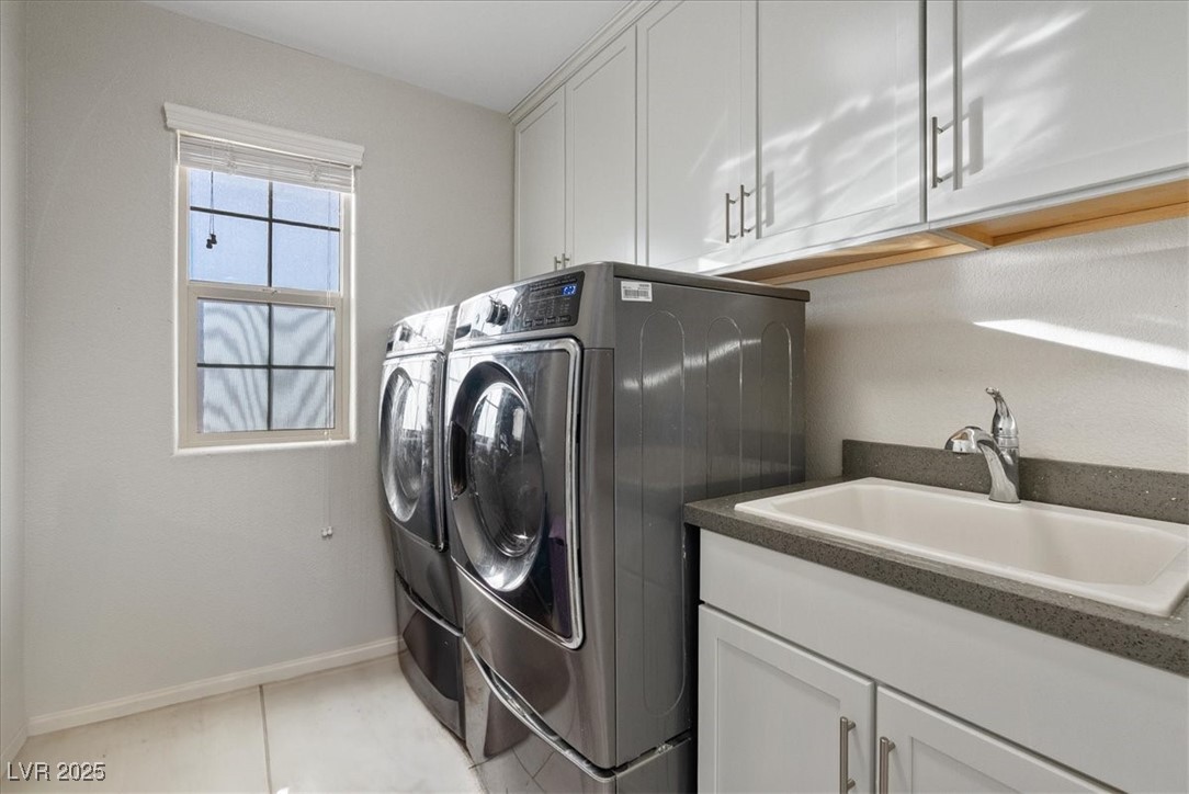936 Keesey Way Henderson, NV 89052 - Photo 26 of 30 Laundry area with cabinet space, washing machine and clothes dryer, and light tile patterned floors