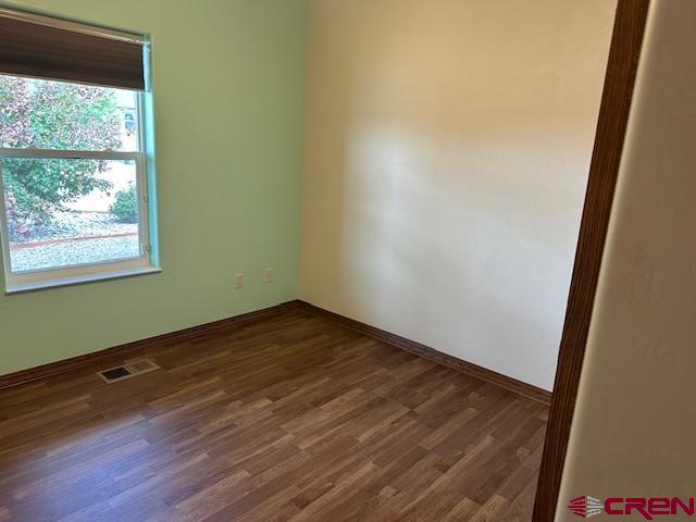 1941 Kaleigh Circle Cortez, CO 81321 - Photo 27 of 35 an empty room with wooden floor and windows