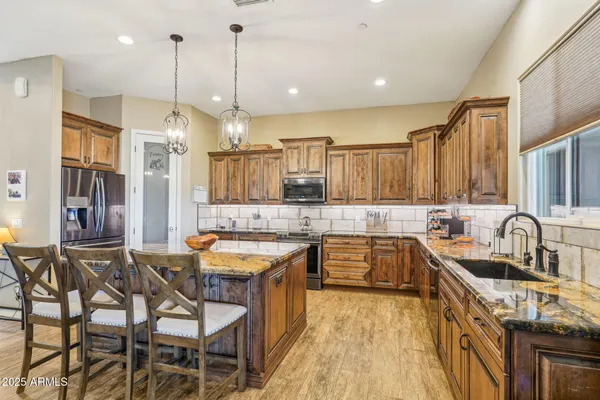 a kitchen with granite countertop a sink stove and refrigerator