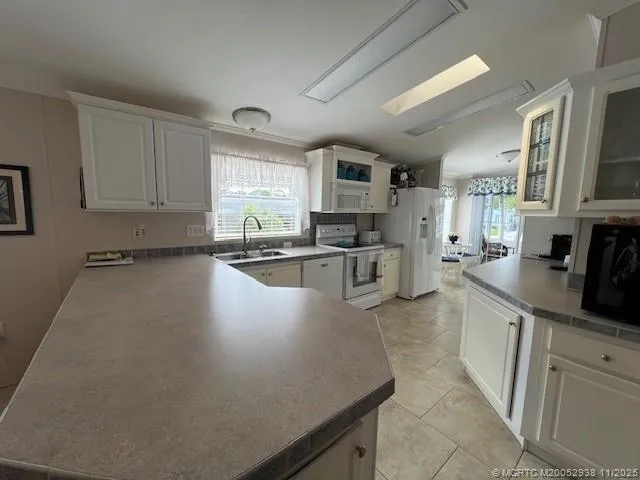 a kitchen with stainless steel appliances a sink a stove top oven a counter space and cabinets