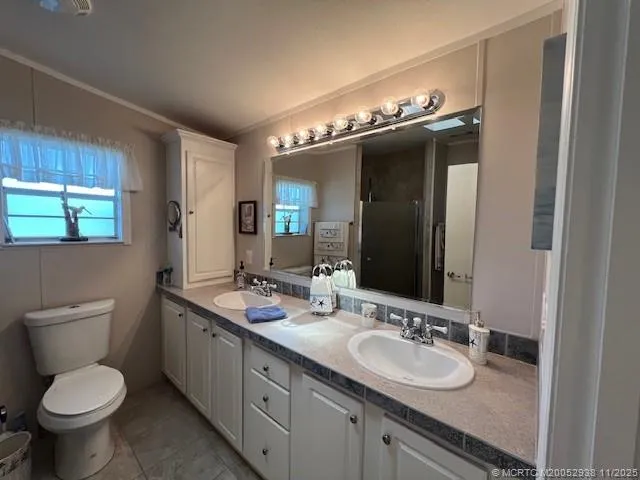 a bathroom with a granite countertop toilet sink and mirror