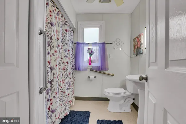 a bathroom with a toilet and a shower curtain