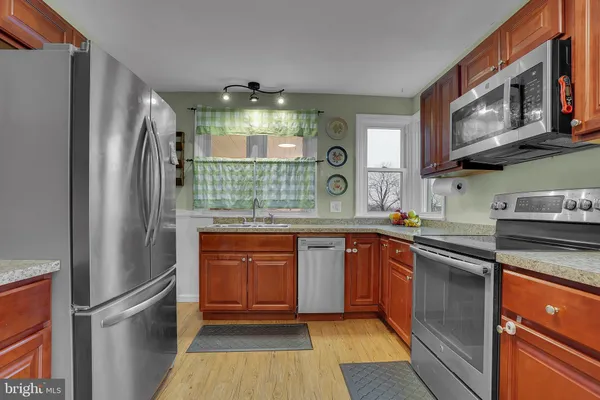 a kitchen with stainless steel appliances granite countertop a refrigerator and a sink