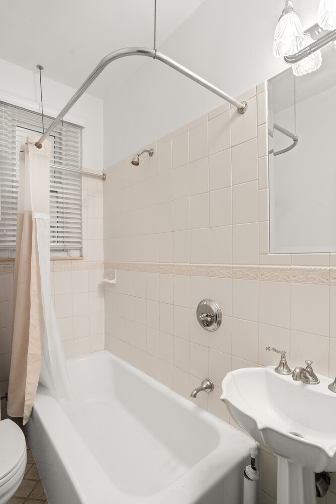12 East 87th Street, Unit 6D Manhattan, NY 10028 - Photo 6 of 8 a bathroom with a sink a toilet and shower