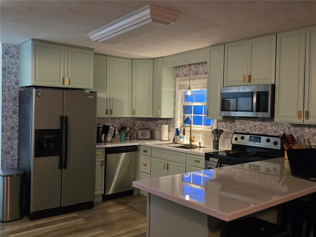 7 Bass Street Panacea, FL 32346 - Photo 3 of 11 a kitchen with stainless steel appliances granite countertop a refrigerator stove microwave and sink