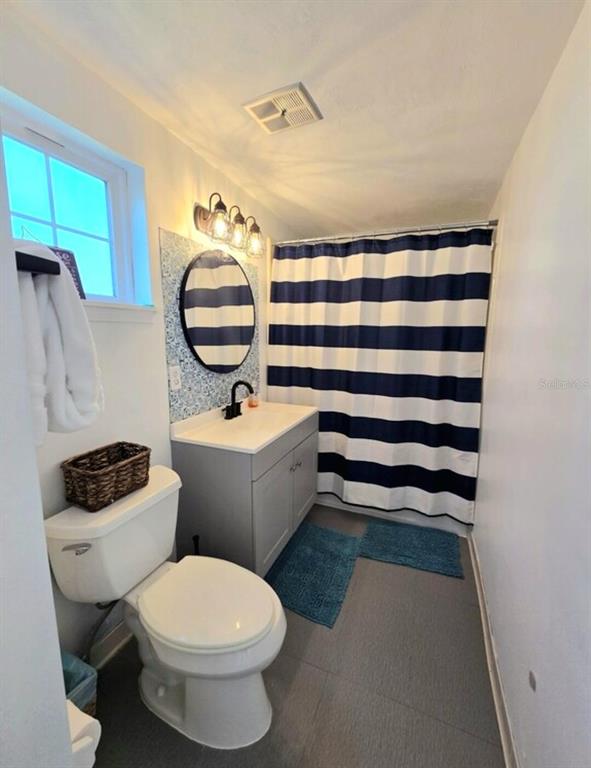 7 Bass Street Panacea, FL 32346 - Photo 8 of 11 a bathroom with a sink a toilet and a mirror