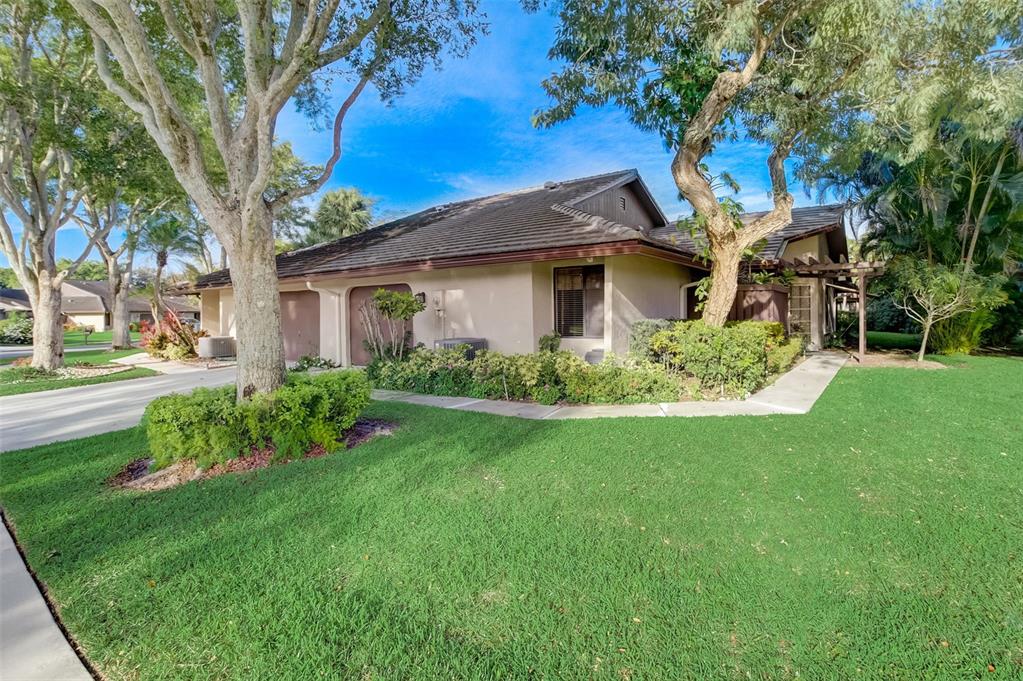 5051 Pine Drive Boynton Beach, FL 33437 - Photo 1 of 40 a front view of a house with garden