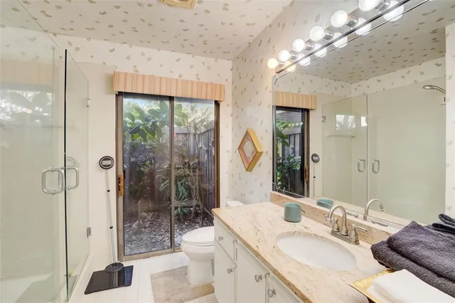 a bathroom with a granite countertop sink toilet and shower