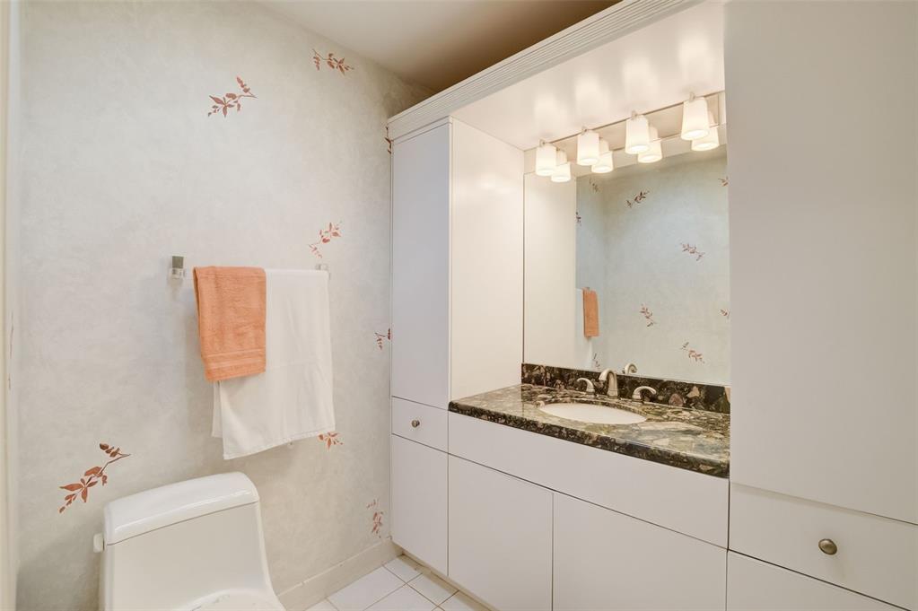 5051 Pine Drive Boynton Beach, FL 33437 - Photo 29 of 40 a bathroom with a granite countertop sink a toilet and a mirror