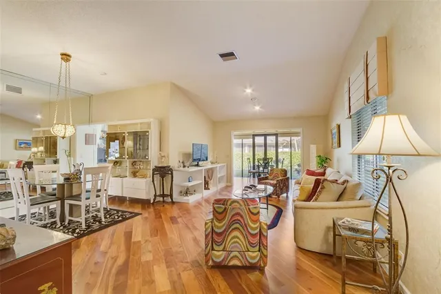 a living room with furniture large window and chandelier