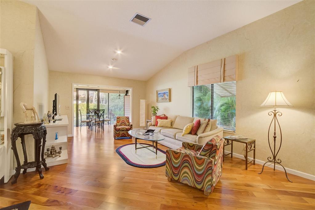 5051 Pine Drive Boynton Beach, FL 33437 - Photo 5 of 40 a living room with furniture a floor to ceiling window and wooden floor