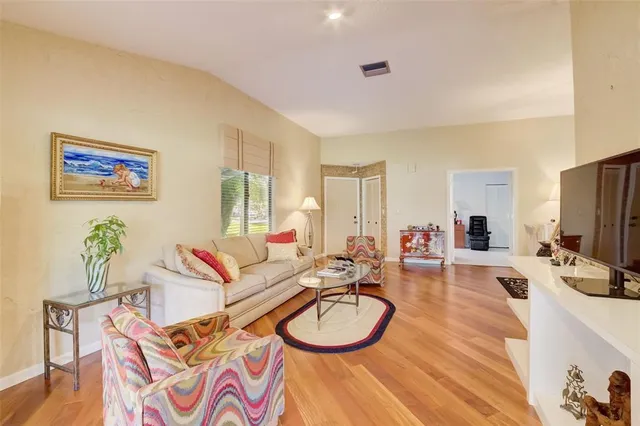 a living room with furniture a flat screen tv and a large window