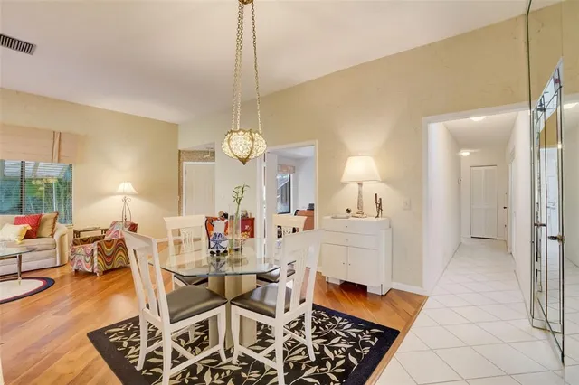 a view of a dining room and livingroom with furniture wooden floor a chandelier