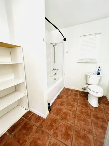 a bathroom with a toilet and a shower