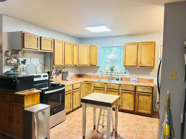 a kitchen with stainless steel appliances granite countertop sink stove top oven and cabinets