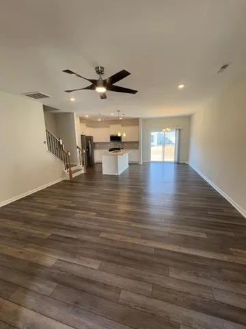 a view of empty room with wooden floor and windows