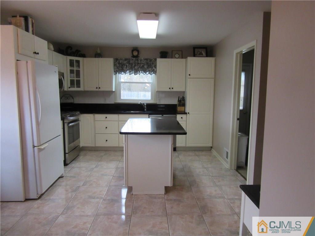 63 Royce Brook Road Hillsborough, NJ 08844 - Photo 2 of 25 a kitchen with granite countertop a refrigerator and a sink