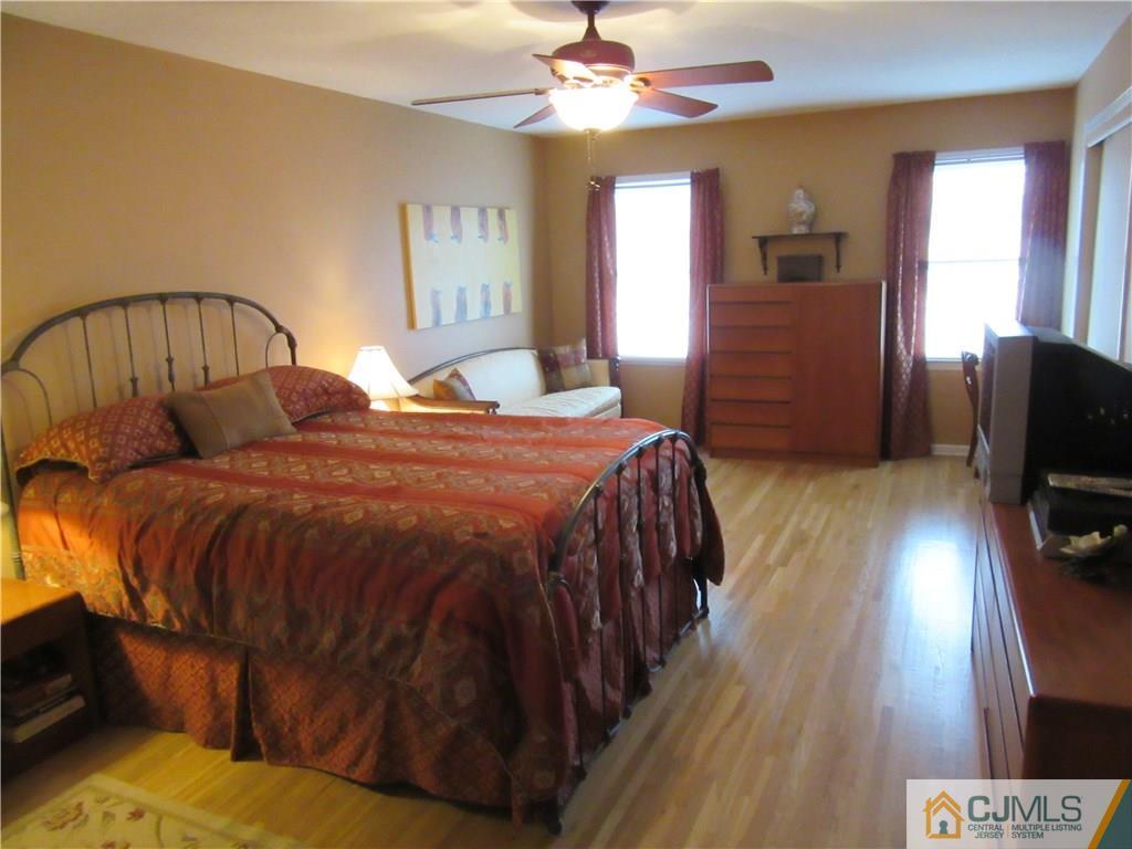 63 Royce Brook Road Hillsborough, NJ 08844 - Photo 12 of 25 a bedroom with a bed and a flat tv screen on dresser