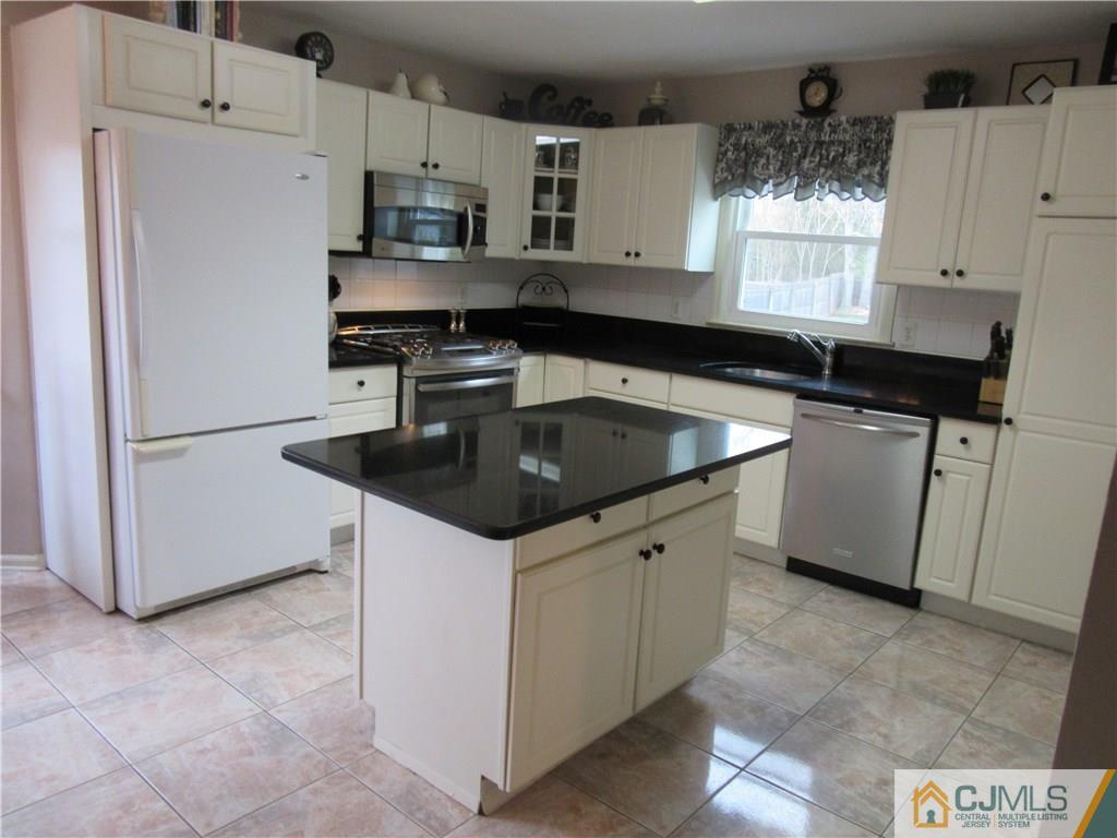 63 Royce Brook Road Hillsborough, NJ 08844 - Photo 3 of 25 a kitchen with stainless steel appliances granite countertop a sink stove and refrigerator