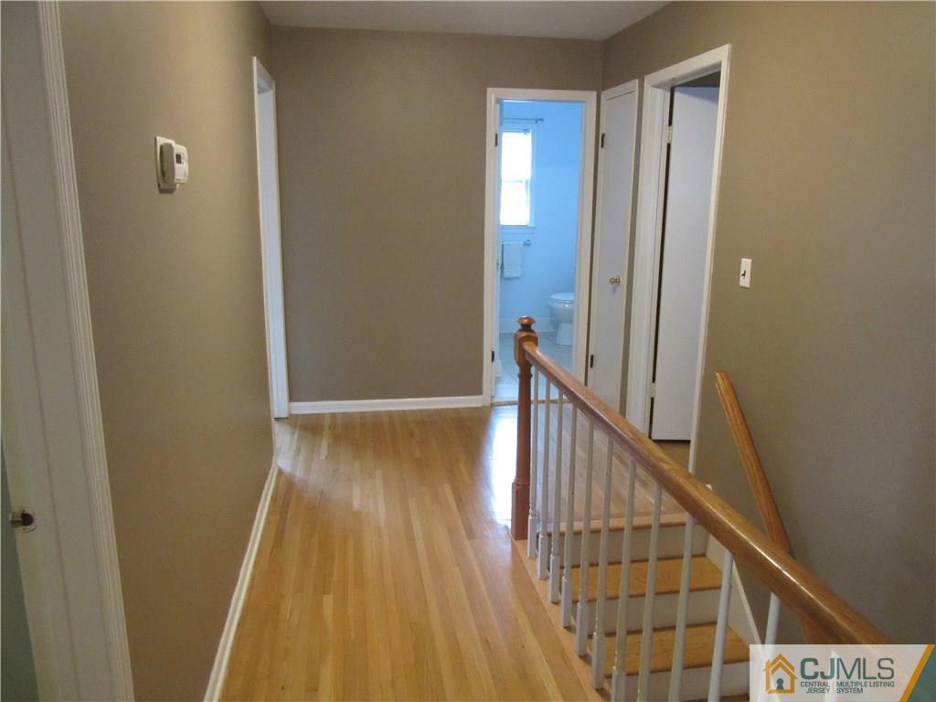 63 Royce Brook Road Hillsborough, NJ 08844 - Photo 23 of 25 a view of a hallway with wooden floor and staircase