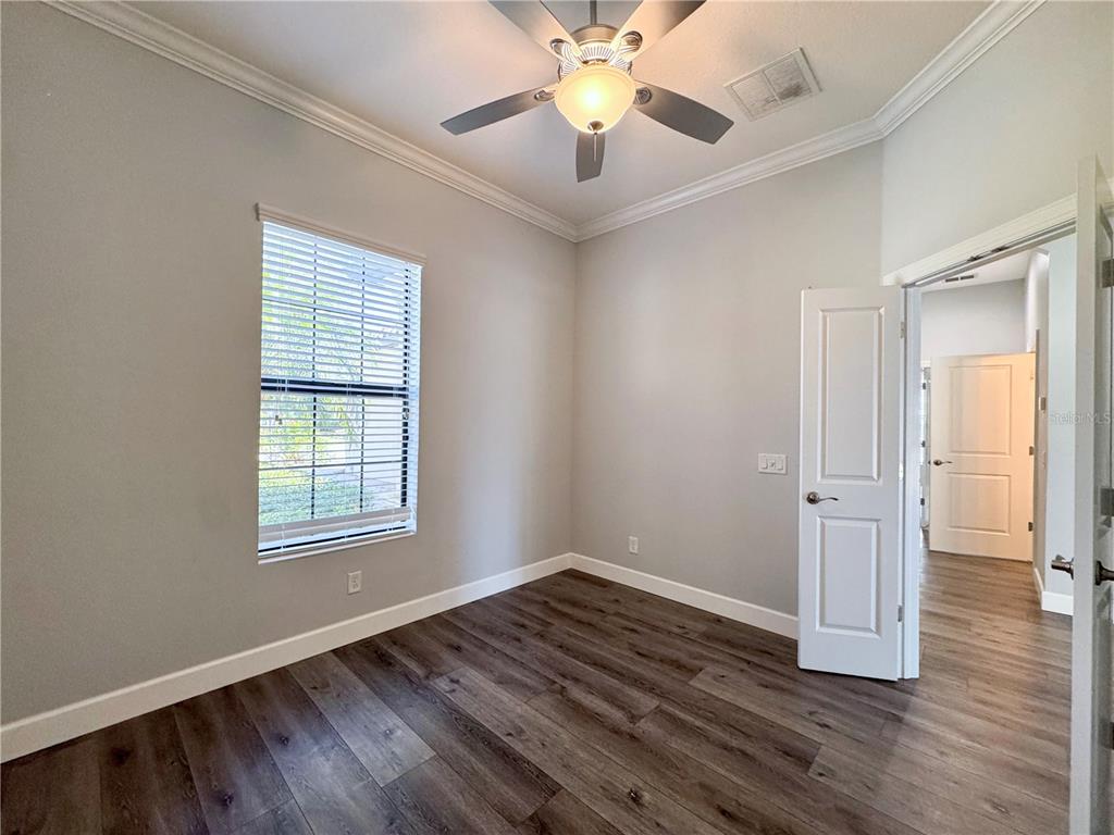 12822 Del Corso Loop Bradenton, FL 34211 - Photo 12 of 58 an empty room with wooden floor chandelier fan and windows