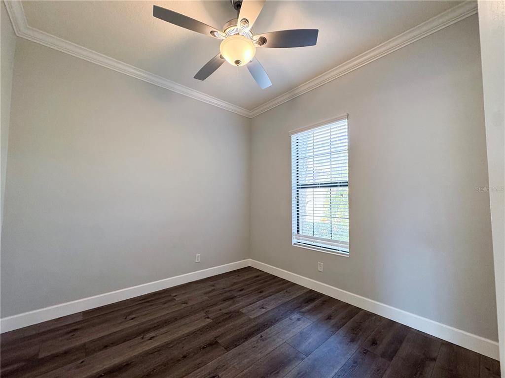 12822 Del Corso Loop Bradenton, FL 34211 - Photo 13 of 58 an empty room with wooden floor ceiling fan and windows