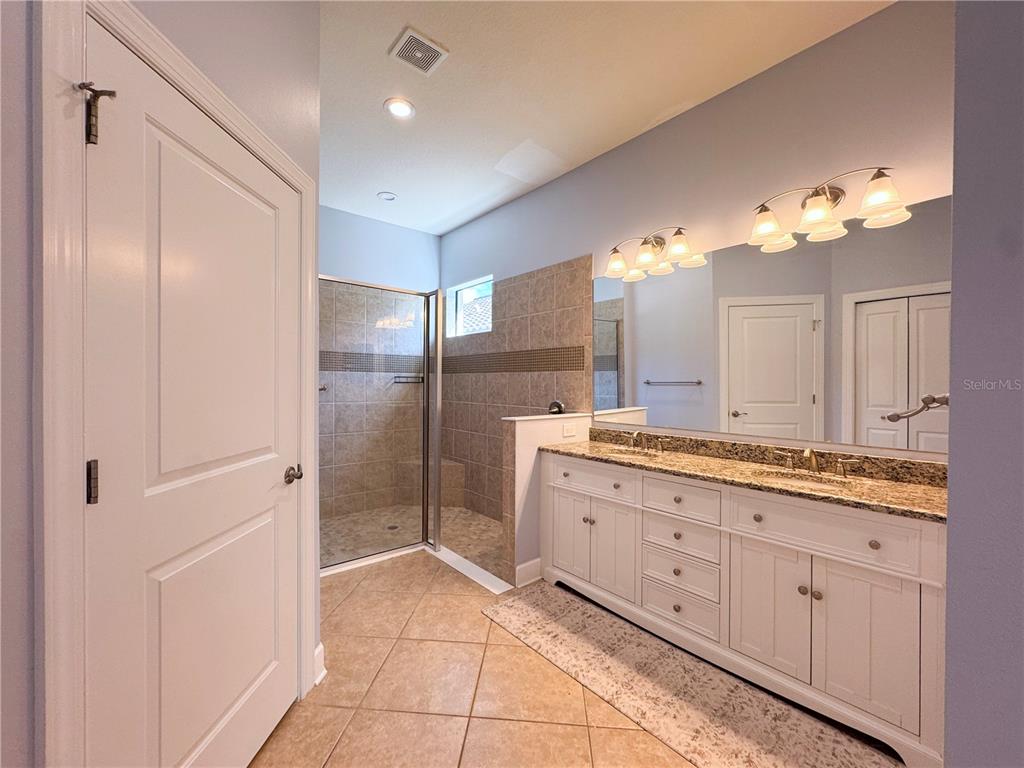 12822 Del Corso Loop Bradenton, FL 34211 - Photo 18 of 58 a bathroom with a granite countertop sink a mirror and a shower