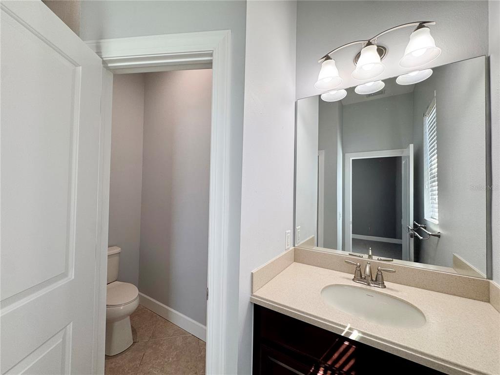 12822 Del Corso Loop Bradenton, FL 34211 - Photo 25 of 58 a bathroom with a toilet a sink and a mirror