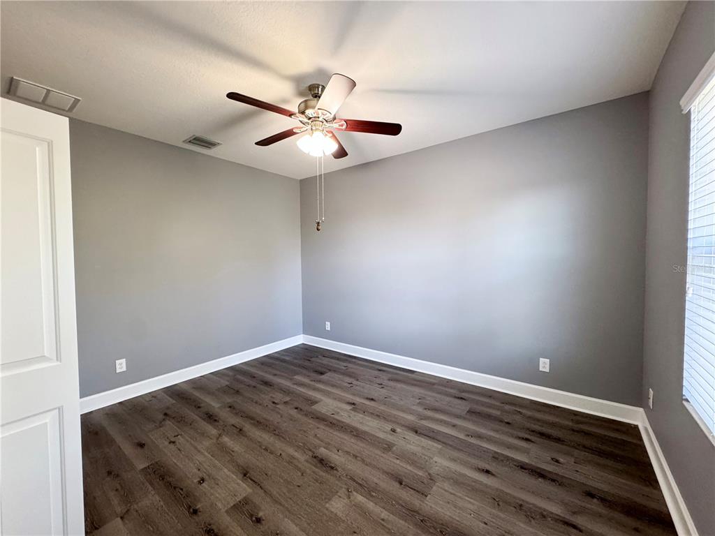 12822 Del Corso Loop Bradenton, FL 34211 - Photo 37 of 58 an empty room with wooden floor fan and windows
